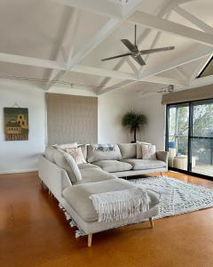 a living room with a couch and a ceiling fan at Boutique Coastal Beach House Cowes Phillip Island Sleeps 8 in Cowes