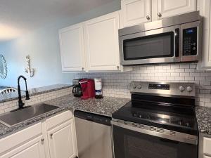 a kitchen with a stove and a microwave at Family Getaway - Boardwalk to the Beach, 3 pools, Tennis in Hilton Head Island