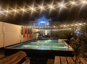 a swimming pool with lights in a house at night at Sea lumina in Varkala