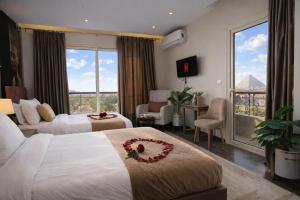 a hotel room with two beds and a large window at Hammis Pyramids View INN in Cairo