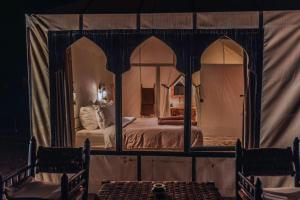 a bedroom with a bed in a tent at Luxury Camp Sahara in Merzouga