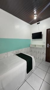 a bedroom with a bed and a flat screen tv at Hotel Maracá in Boa Vista