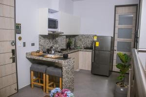 a kitchen with a counter and a refrigerator at Aparta Hotel Loft 1985 Awaliba in Puerto Gaitán