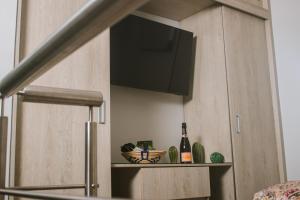 a kitchen with a cabinet with a television and a bottle of wine at Aparta Hotel Loft 1985 Awaliba in Puerto Gaitán +10 photos
