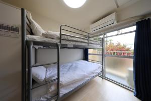 a room with two bunk beds and a window at Tsurumai Nagoya Stay in Nagoya