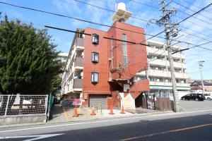 a red brick building on the side of a street at Tsurumai Nagoya Stay in Nagoya