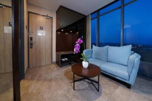 a living room with a blue couch and a table at Aston Inn Mataram in Mataram
