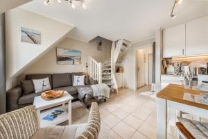 a living room with a couch and a table at LH Dünenblick Wohnung 9 in Wenningstedt