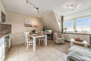 a kitchen and dining room with a table and chairs at LH Dünenblick Wohnung 9 in Wenningstedt