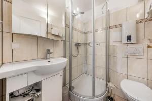 a bathroom with a sink and a shower at LH Dünenblick Wohnung 9 in Wenningstedt +11 photos