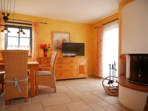 a living room with a table and a television at Mohnblume in Am Schwarzen Busch