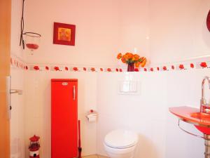 a bathroom with a red toilet and a sink at Mohnblume in Am Schwarzen Busch +14 photos