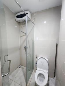 a bathroom with a toilet with a glass shower stall at Hotel Training Center UIN Mataram in Mataram +8 photos