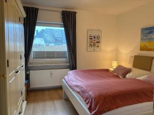 a bedroom with a bed and a large window at Vierfuss 1A in Hörnum