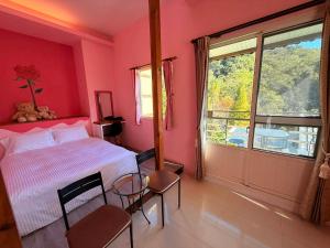 a bedroom with pink walls and a bed and a window at Xiangyang Tianyuan in Sanyi
