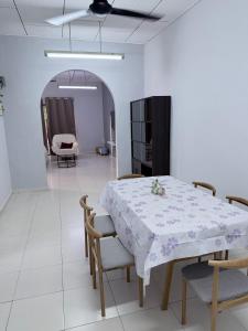 a dining room with a white table and chairs at Greeny Homestay in Muar