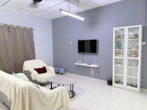 a living room with a couch and a tv at Greeny Homestay in Muar