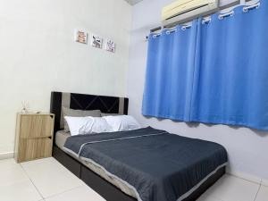 a bedroom with a bed with a blue curtain at Greeny Homestay in Muar