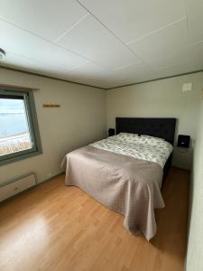 a bedroom with a bed in a room with a window at Koselig feriehus ved sjøen - Skjevikstranden in Steinkjer