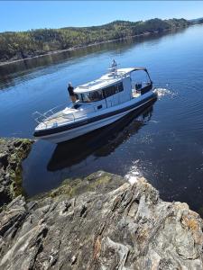 a boat in the water on a river at Koselig feriehus ved sjøen - Skjevikstranden in Steinkjer