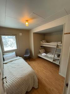 a small bedroom with a bed and a window at Koselig feriehus ved sjøen - Skjevikstranden in Steinkjer