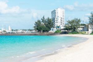 a view of a beach with a building in the background at タイガーMiyako in Miyako-jima