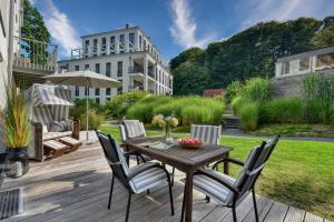 a patio with a table and chairs and a building at Ferienwohnung Baltic Lounge in der Villa Amalie Binz in Binz
