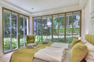 a bedroom with a large bed and large windows at Ferienwohnung Baltic Lounge in der Villa Amalie Binz in Binz
