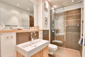 a bathroom with a sink and a toilet and a shower at Ferienwohnung Baltic Lounge in der Villa Amalie Binz in Binz +14 photos
