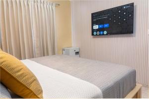 a bedroom with a bed and a tv on the wall at Villa Lionisia in Puerto Plata
