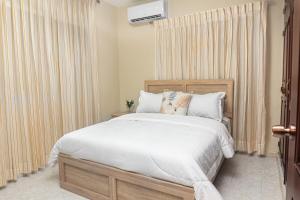 a bedroom with a bed with white sheets and pillows at Villa Lionisia in Puerto Plata +21 photos