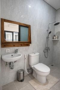 a bathroom with a toilet and a sink and a mirror at Sachi Guest House in Jimbaran
