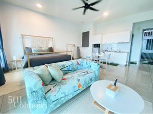 a living room with a blue couch and a bed at Cyberjaya - Netflix - Disney - Wifi in Cyberjaya