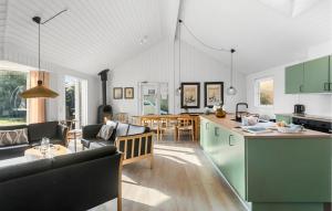 a kitchen and living room with a couch and a table at Amazing Home In Idestrup With Sauna in Bøtø By