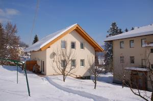 ein Haus im Schnee davor in der Unterkunft Villa Marienhof in Annenheim