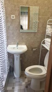 a bathroom with a sink and a toilet and a mirror at Grace View Villa in Trofwi