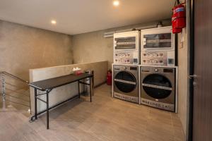 a laundry room with two washing machines and a table at Trifena Residence in Kalibanteng-lor