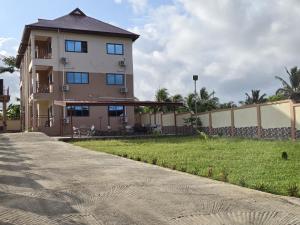 a tall building with a grass yard in front of it at Grace View Villa in Trofwi