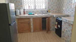 a kitchen with a sink and a refrigerator at Grace View Villa in Trofwi