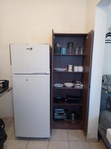 a white refrigerator in a kitchen next to a pantry at Casa Capuchina in Querétaro