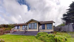 a small house in a yard with a fence at Tideaway Private Hot Tub and Expansive Ocean View in Fort Bragg