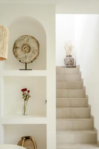 a staircase with two vases and a clock on the wall at The Belluoccio Villa Pererenan in Tumbak Bayuh