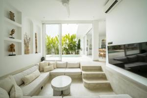 a living room with a couch and a table at The Belluoccio Villa Pererenan in Tumbak Bayuh