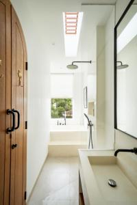 a bathroom with a tub and a sink and a window at The Belluoccio Villa Pererenan in Tumbak Bayuh