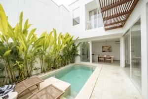 an indoor pool in a house with plants at The Belluoccio Villa Pererenan in Tumbak Bayuh +25 photos