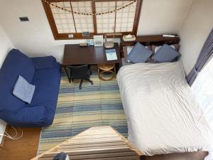 a bedroom with a bed and a desk and a table at Kasumi-an in Kumamoto