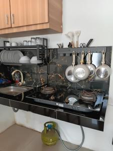 a kitchen with a stove with pots and pans at Adah 786 Villa Syariah in Krian