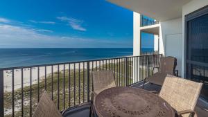 a balcony with a table and chairs and the ocean at Phoenix VI 61204 in Orange Beach