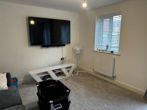 a living room with a flat screen tv on the wall at Dzingai Home in Newport
