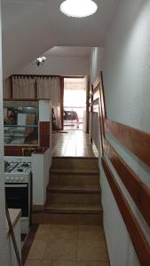 a stairway leading to a kitchen with a stove at Triplex waltito in San Clemente del Tuyu